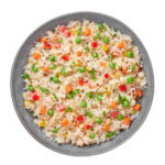 Veg Fried Rice in gray bowl isolated on white backdrop. Veg Fried rice is indo chinese cuisine dish. Indian vegetarian meal. Asian food. Top view